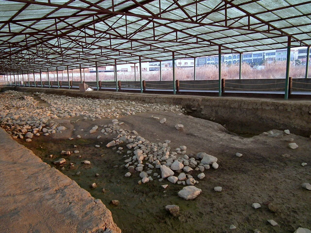 Preserved remains of the western city wall beneath a protective roof at Liangzhu.