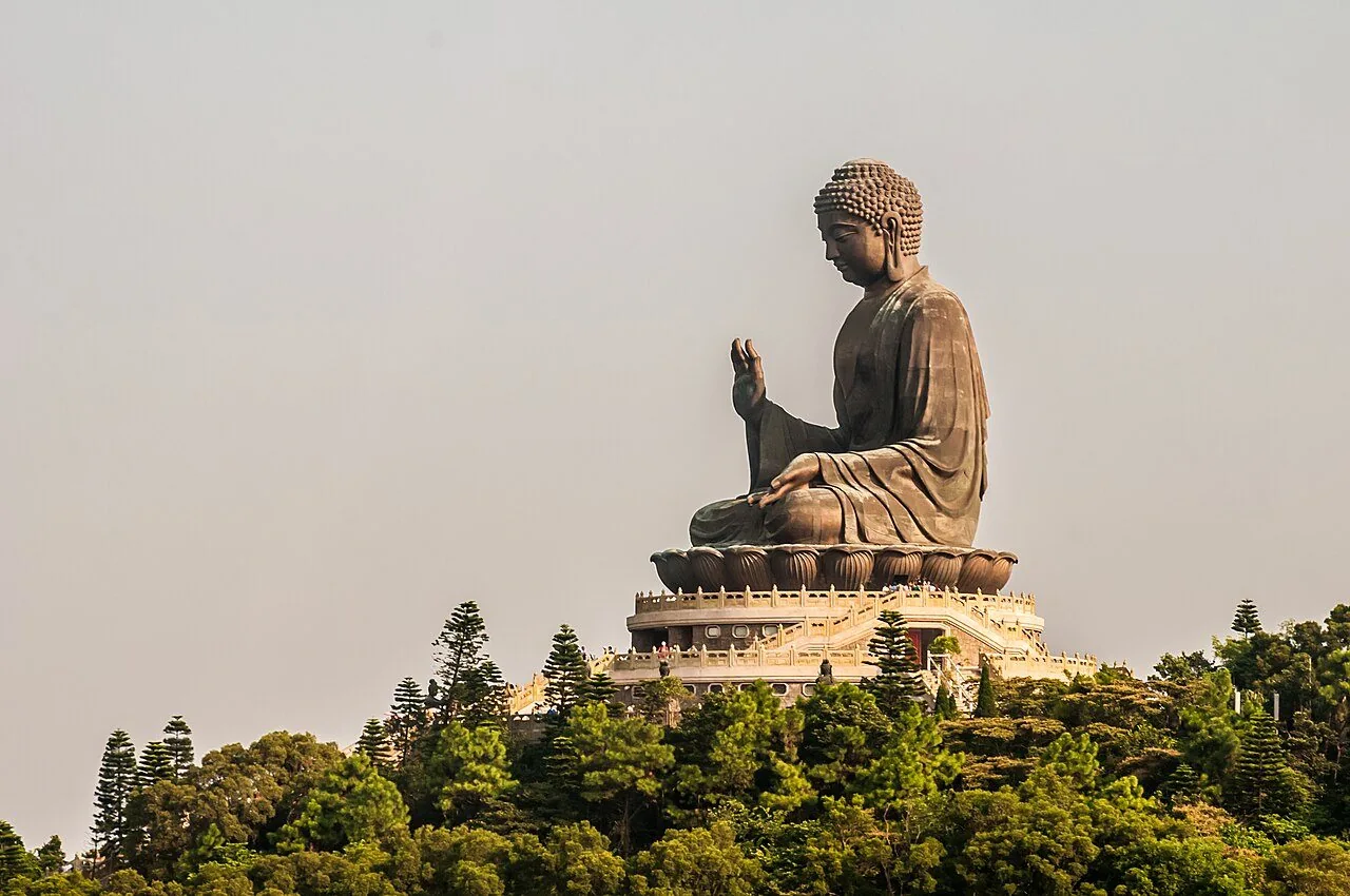 The Tian Tan Buddha above green hills on Lantau Island.